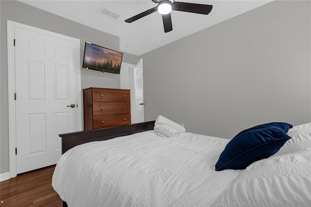 bedroom with ceiling fan, dark wood finished floors, and visible vents