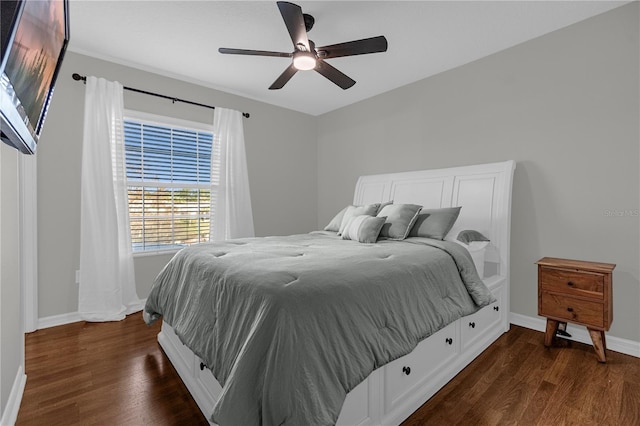 bedroom featuring dark wood-type flooring, a ceiling fan, and baseboards