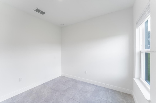 spare room featuring visible vents and baseboards