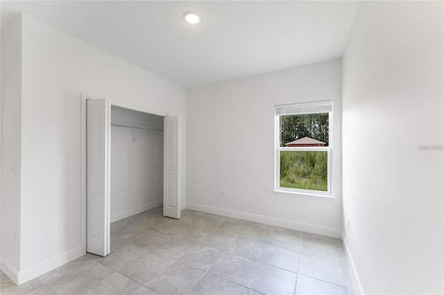 unfurnished bedroom with baseboards and a closet