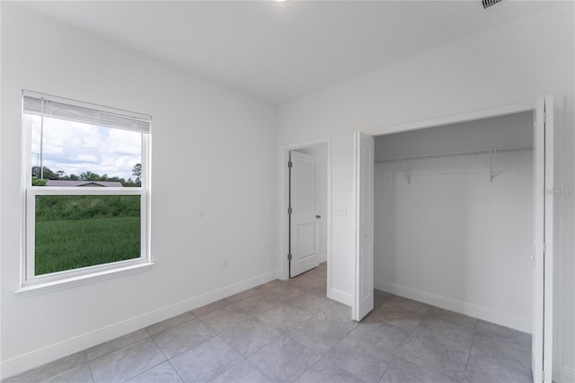 unfurnished bedroom with baseboards and a closet