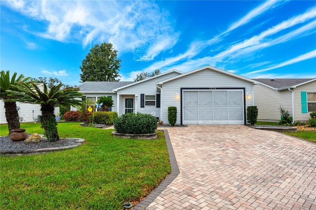 single story home with a garage, a front lawn, and decorative driveway