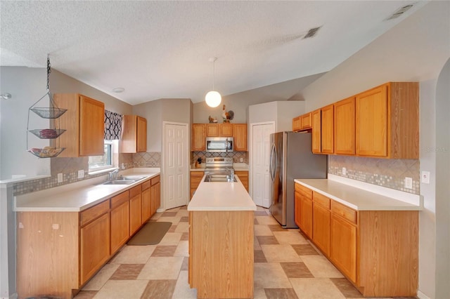 kitchen featuring stainless steel appliances, lofted ceiling, light countertops, a kitchen island with sink, and a sink