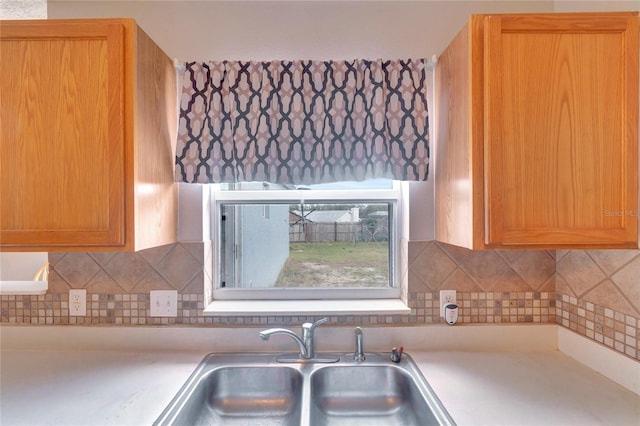 kitchen featuring light countertops, a sink, and decorative backsplash