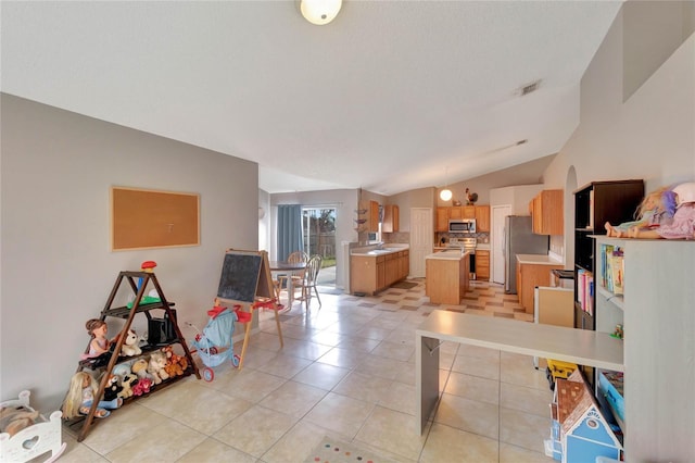 living room featuring lofted ceiling, light tile patterned floors, visible vents, and a textured ceiling