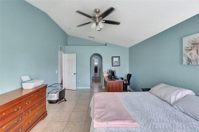 bedroom featuring lofted ceiling, light tile patterned floors, visible vents, and arched walkways