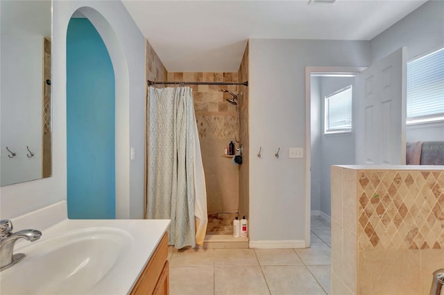 full bath featuring vanity, visible vents, tiled shower, and tile patterned floors