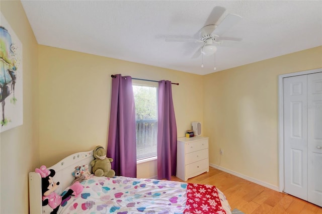 bedroom with ceiling fan, light wood finished floors, and baseboards