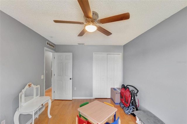 game room featuring visible vents, a textured ceiling, and light wood finished floors