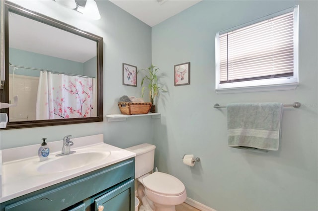 bathroom with curtained shower, vanity, toilet, and baseboards