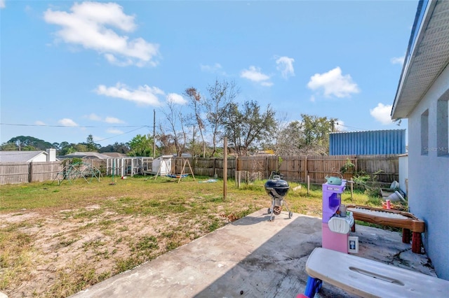 view of yard featuring a fenced backyard, a patio, and an outdoor structure