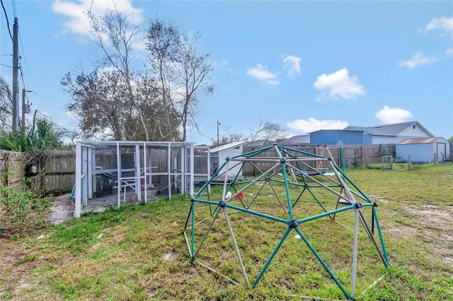 view of playground featuring a fenced backyard, an outdoor structure, exterior structure, and a lawn