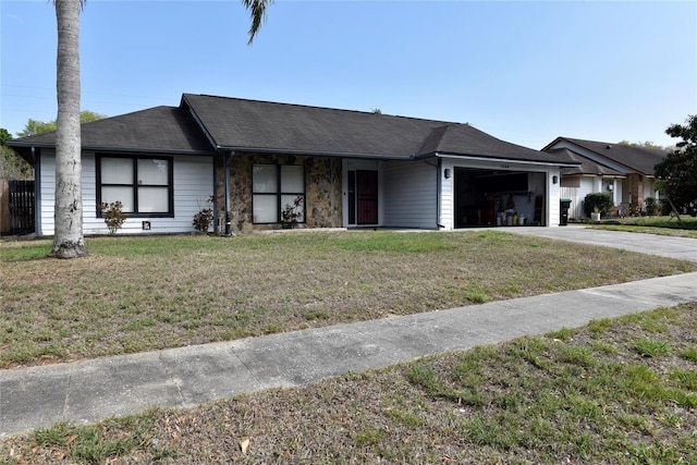 view of front of home with an attached garage, driveway, and a front lawn