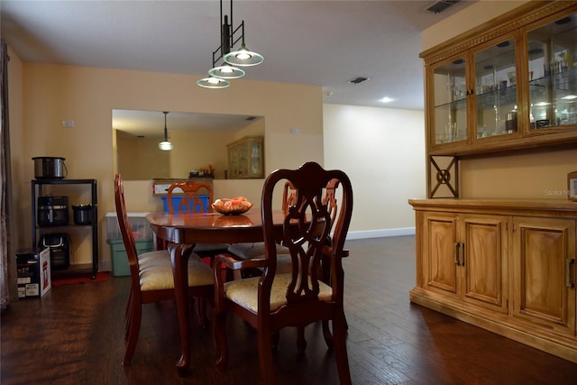 dining space featuring visible vents, baseboards, and dark wood-style floors