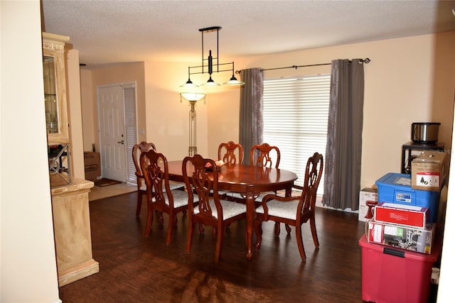 dining area featuring dark wood-style flooring and a textured ceiling