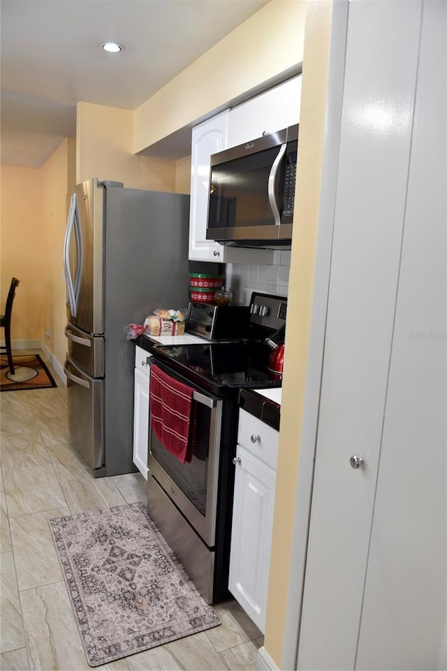 kitchen featuring backsplash, white cabinets, stainless steel appliances, and dark countertops