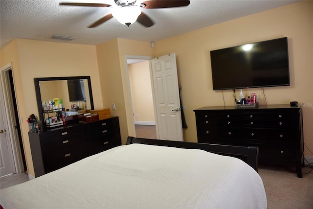 bedroom with visible vents, a textured ceiling, ceiling fan, and carpet flooring