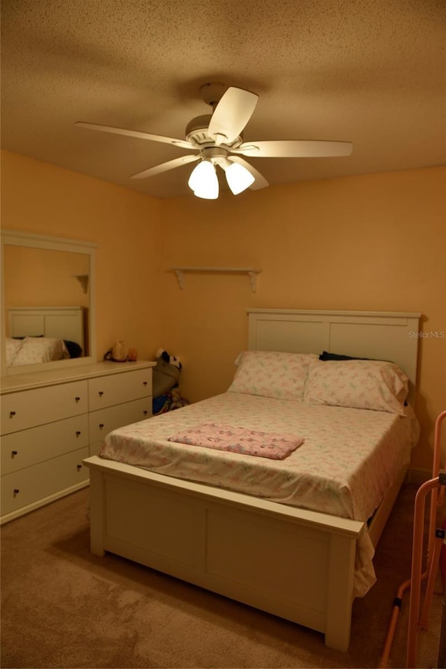 bedroom with a ceiling fan, carpet, and a textured ceiling