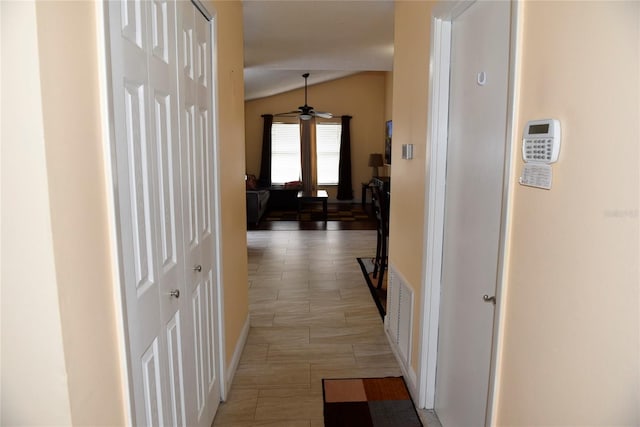 hallway with visible vents and lofted ceiling