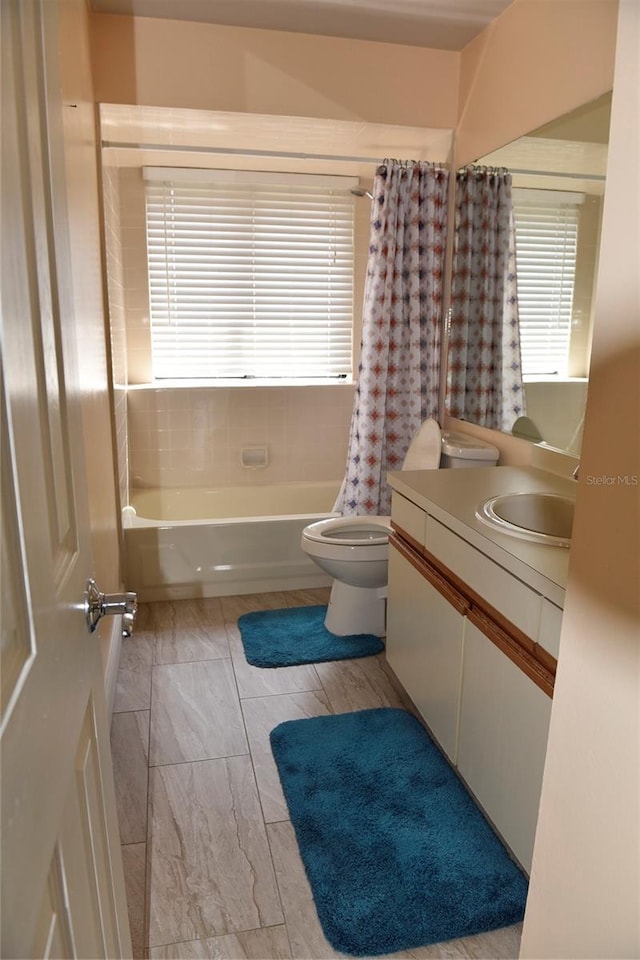 full bathroom featuring shower / bath combo with shower curtain, toilet, and vanity