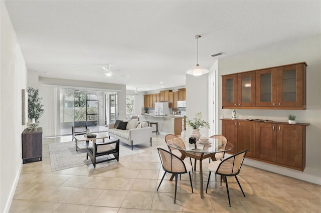 dining area featuring baseboards, visible vents, and light tile patterned flooring