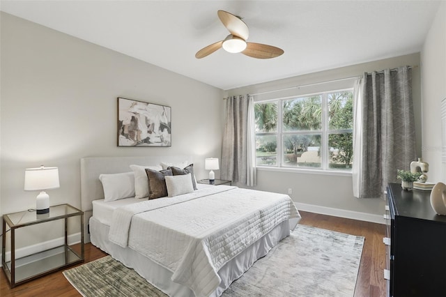 bedroom featuring wood finished floors, a ceiling fan, and baseboards