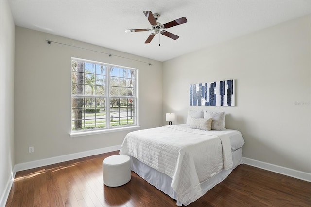 bedroom with ceiling fan, baseboards, and wood finished floors