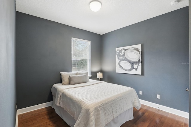 bedroom with baseboards and wood finished floors