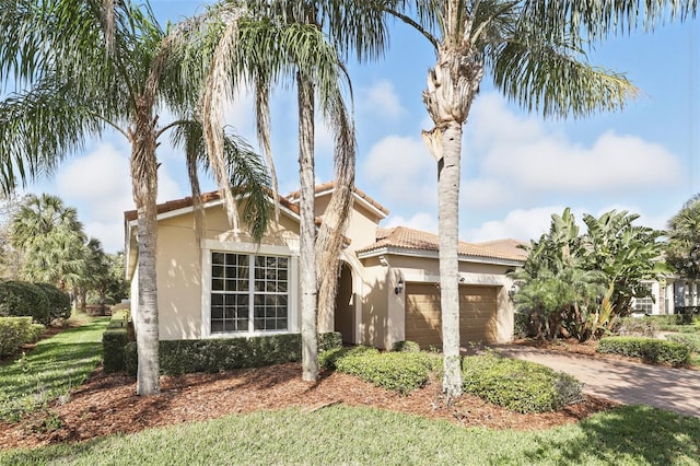 mediterranean / spanish house featuring a garage, driveway, and stucco siding