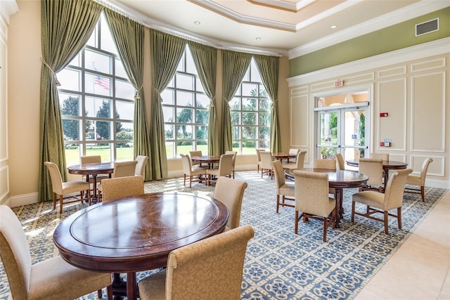 dining room with french doors, crown molding, visible vents, a decorative wall, and tile patterned floors