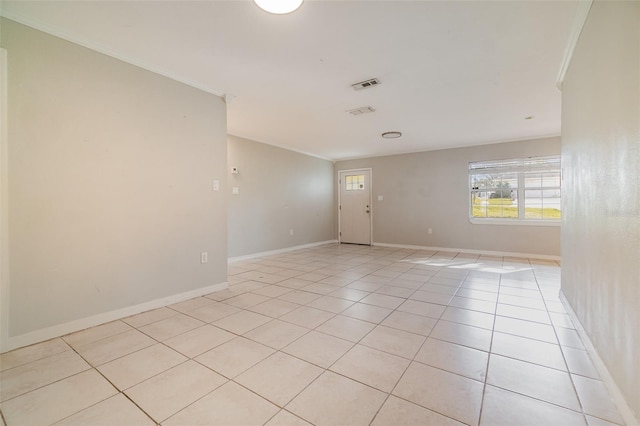 empty room with ornamental molding, visible vents, baseboards, and light tile patterned floors