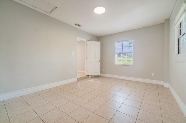 empty room featuring visible vents, baseboards, and light tile patterned flooring