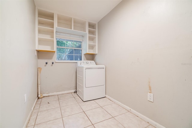 laundry room featuring laundry area, baseboards, light tile patterned floors, and washer / clothes dryer