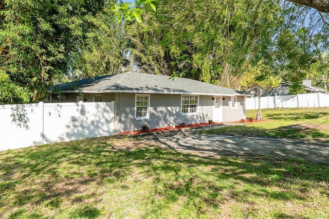 rear view of property featuring a yard and fence