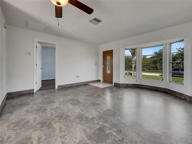 spare room with visible vents, ceiling fan, and baseboards