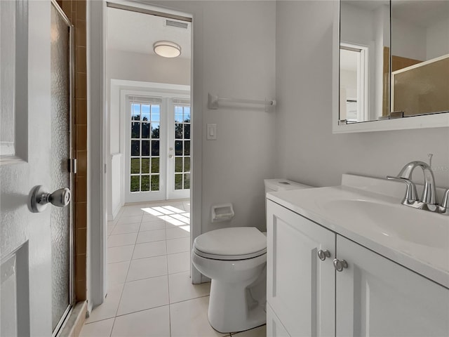 full bath featuring toilet, a stall shower, vanity, and tile patterned floors