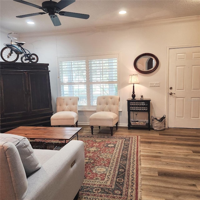 living room with recessed lighting, wood finished floors, baseboards, and ornamental molding