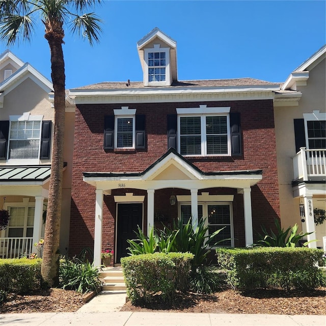 view of front facade with brick siding and a standing seam roof