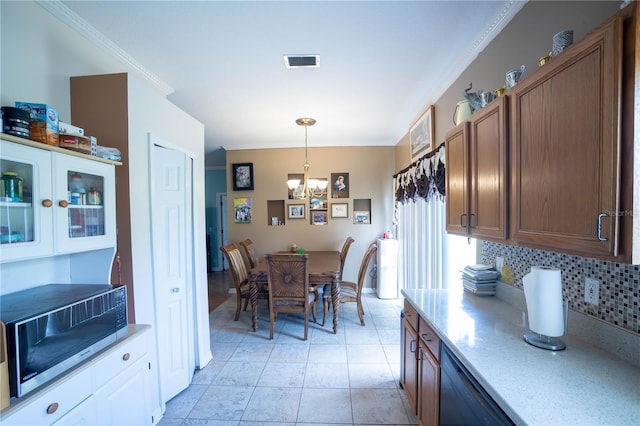 dining room featuring light tile patterned floors, visible vents, a chandelier, and crown molding