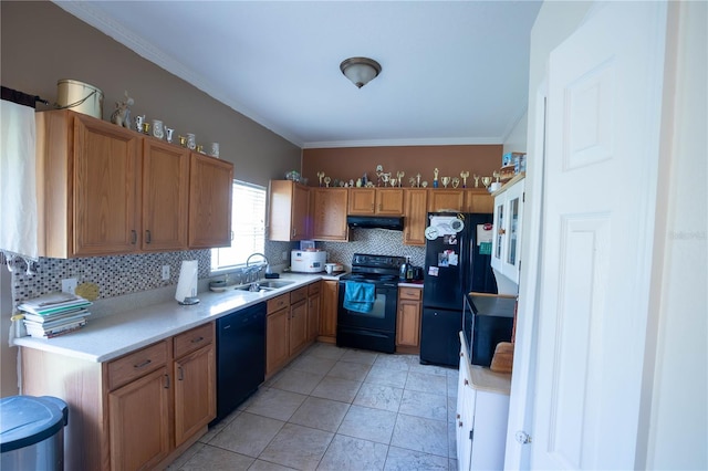 kitchen with under cabinet range hood, a sink, light countertops, decorative backsplash, and black appliances