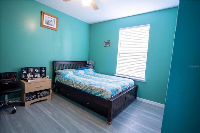 bedroom with ceiling fan, baseboards, and wood finished floors