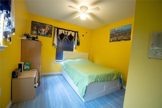 bedroom featuring ceiling fan, baseboards, and wood finished floors