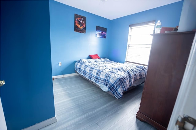 bedroom featuring baseboards and wood finished floors