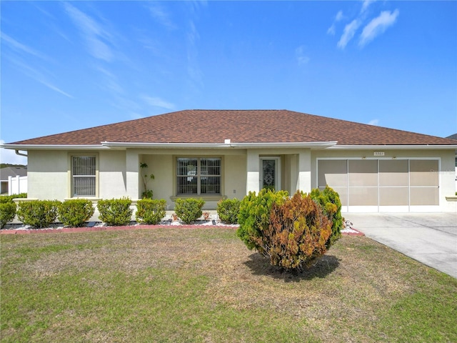 ranch-style home with driveway, stucco siding, roof with shingles, an attached garage, and a front yard