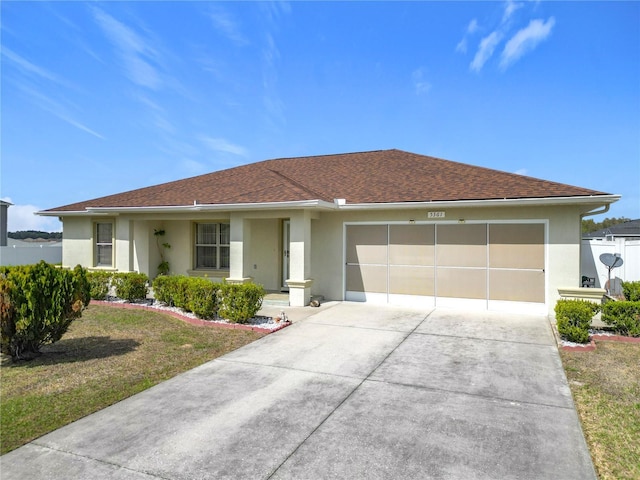 ranch-style house featuring a garage, driveway, a front yard, and stucco siding