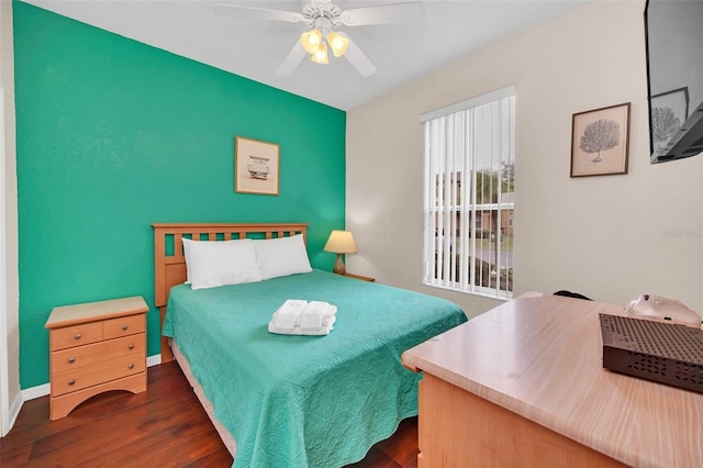 bedroom with dark wood-style floors, baseboards, and a ceiling fan