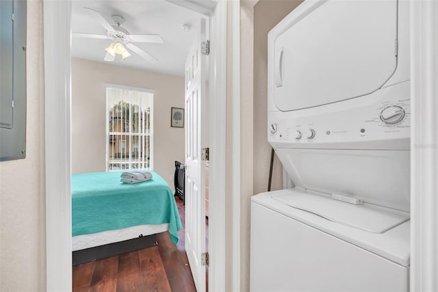 laundry area with laundry area, wood finished floors, stacked washer and clothes dryer, and a ceiling fan