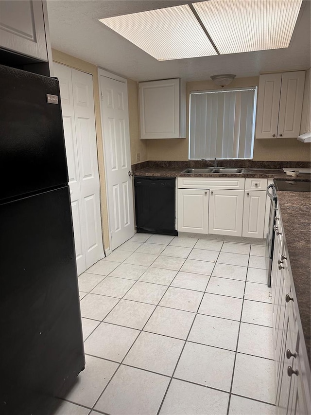 kitchen featuring black appliances, a sink, dark countertops, white cabinetry, and light tile patterned floors