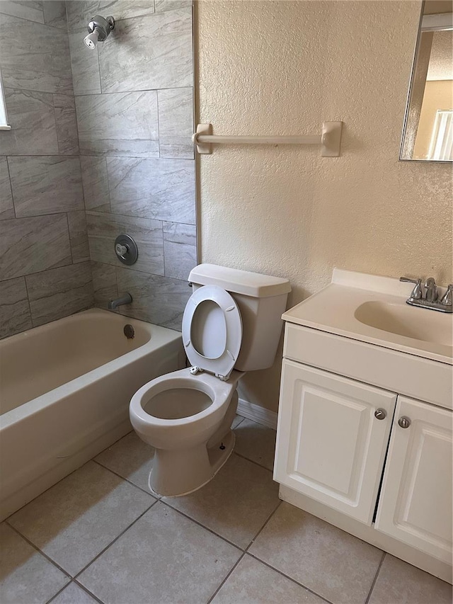 bathroom featuring tile patterned flooring, toilet, shower / bathing tub combination, a textured wall, and vanity