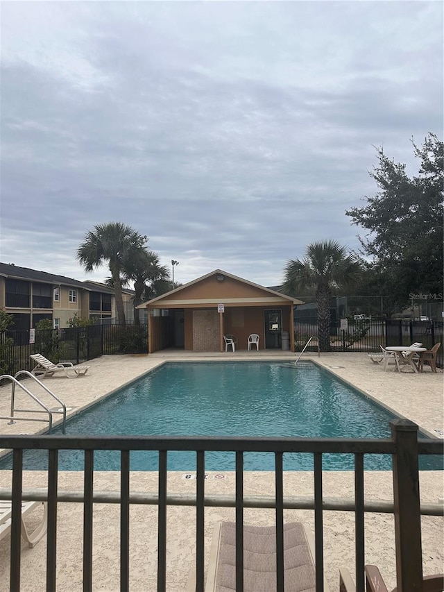 community pool featuring a patio and fence